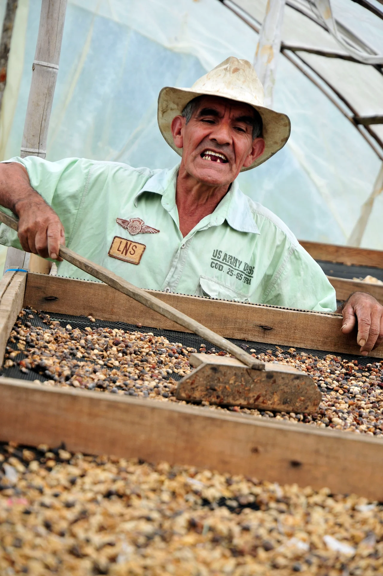 Caficultor trabajando en el secado del café en Cauca, Colombia